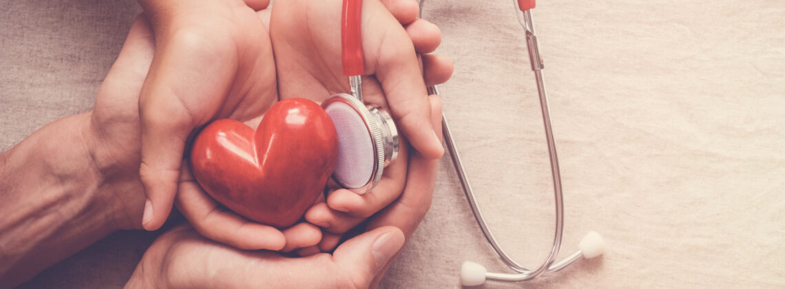 child and adult holding red heart with stethoscope, heart health,  health insurance concept, world heart day, world health day, world hypertension day, health insurance