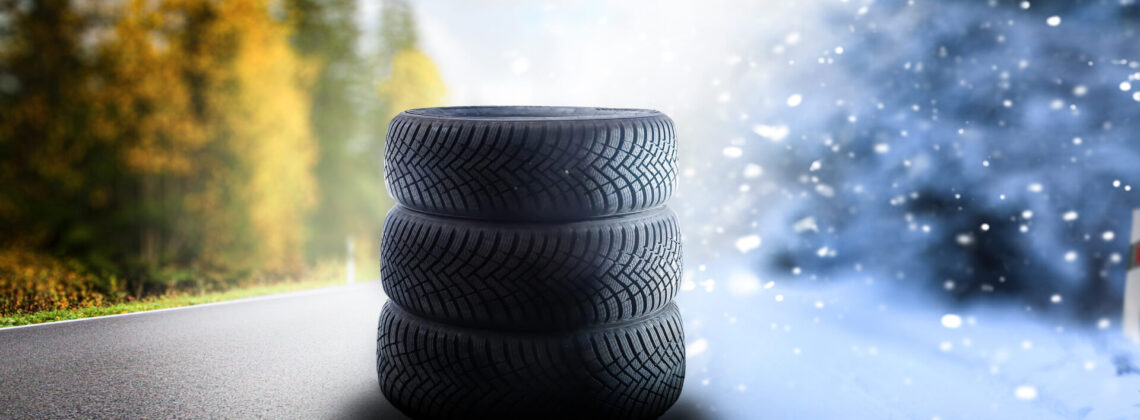 Swap winter tires for summer tires – time for summer tires. Winter tires on a asphalt road. Four wheel off. Change a summer tyre. Forest road with trees in blurred background. Change for new tire.