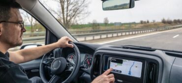 Mężczyzna za kierownicą samochodu, używa nawigacji