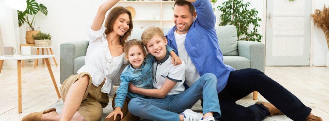 Parents Making Symbolic Roof Joining Hands Above Kids Sitting Indoors